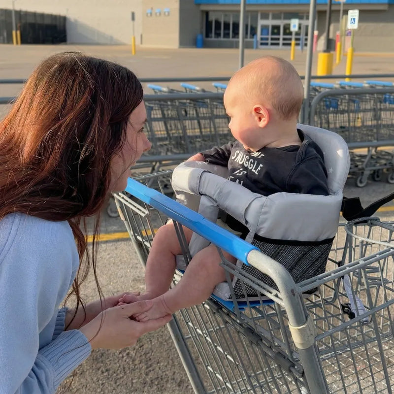 Mother looking at baby seated in Cocoseat shopping cart insert outside store