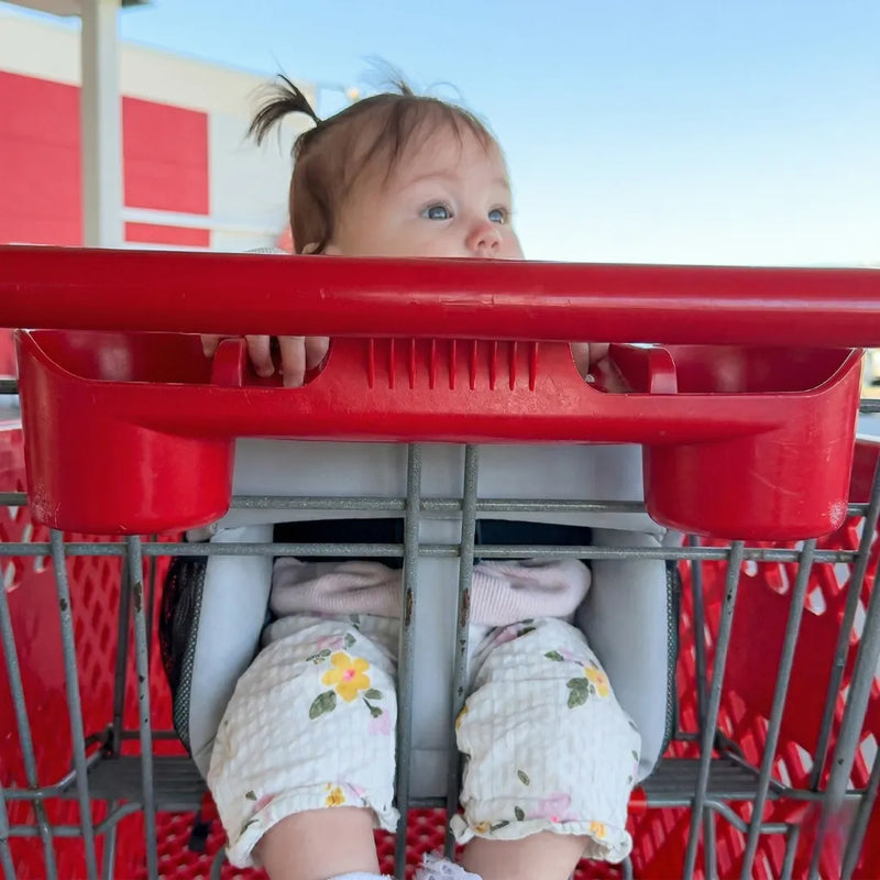 Baby seated in Cocoseat shopping cart insert, low angle view showing padded support